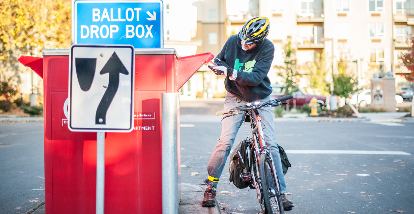 cyclist dropping their election ballot in a drop box